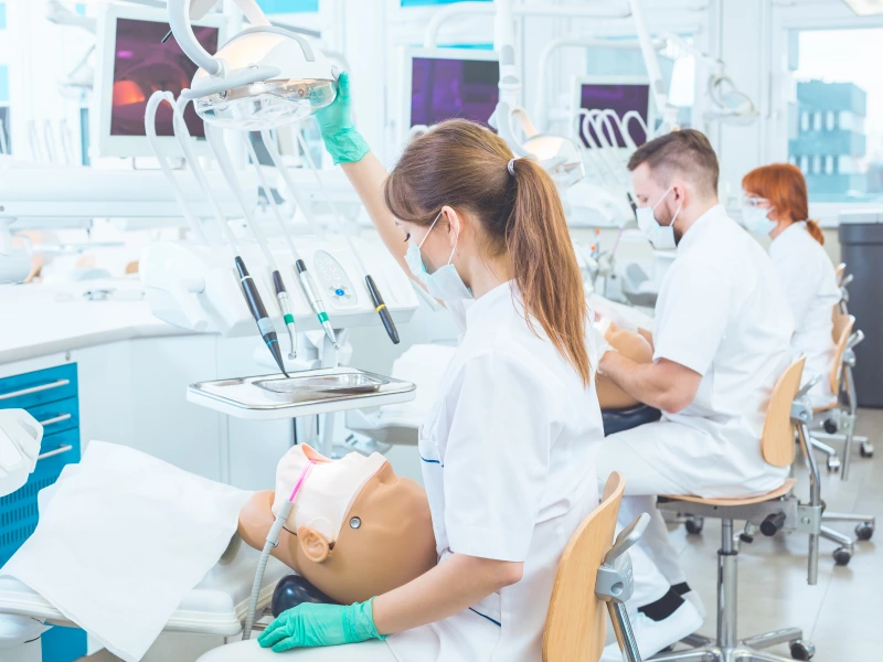 Dental students practicing on a mannequin.